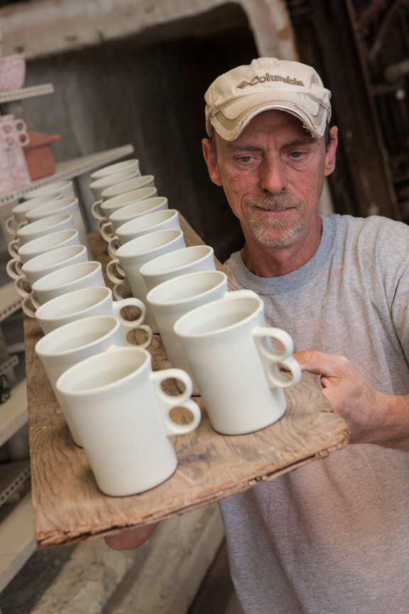 Man holding ceramic fired cups
